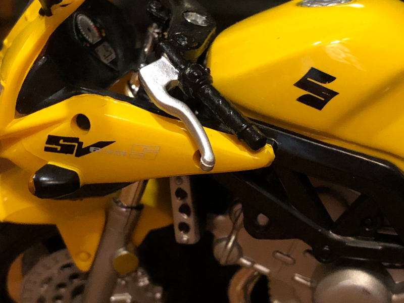 Some detail of the original SV650S badges and stylized S logo on the tank.